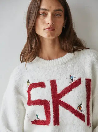 Ivory cream knit ski sweater with bold red SKI letters and skier embroideries