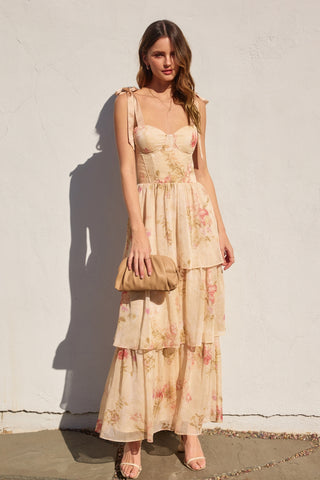 Woman wearing a floral dress against a white wall