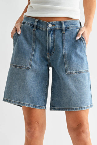 Blue denim shorts worn by a person on a white background