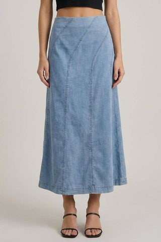 Person wearing a blue denim skirt on a plain background