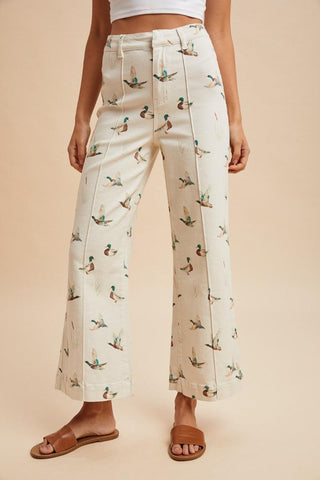 Wide-leg pants with duck pattern worn by a person on a beige background