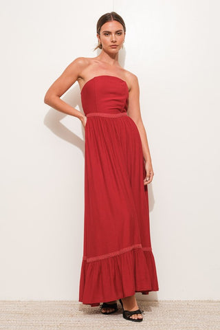 Woman wearing a strapless red dress against a white background