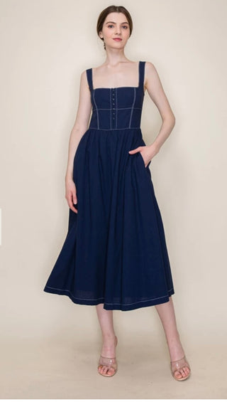 Woman wearing a navy blue dress against a beige background
