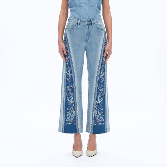 Blue jeans with floral embroidery on a white background
