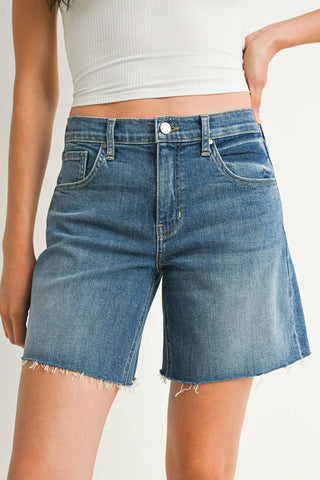 Person wearing blue denim shorts on a plain background