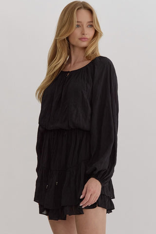 Woman wearing a black dress against a plain background