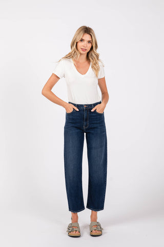 Woman wearing dark jeans against white background