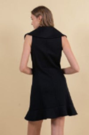 Black dress worn by a person on a beige background