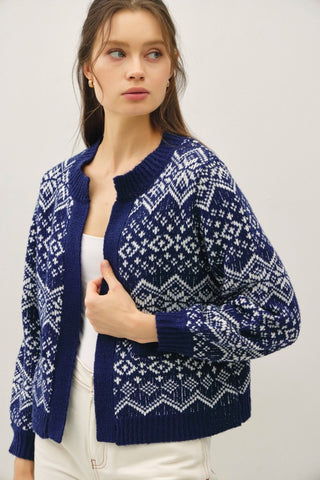 Woman wearing a blue and white patterned sweater against a plain background