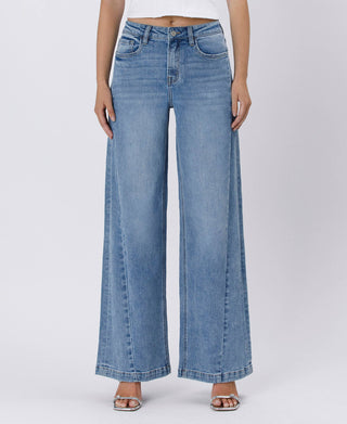 Person wearing light blue wide-leg jeans on a white background