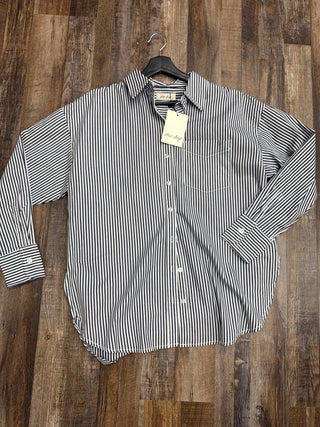 Striped shirt on a hanger with a tag against a wooden background