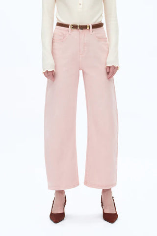Person wearing light pink pants with a white shirt on a white background