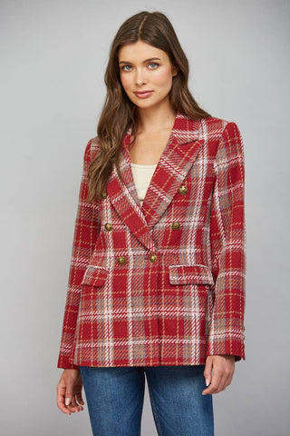 Woman wearing a red plaid double-breasted blazer with gold buttons over jeans