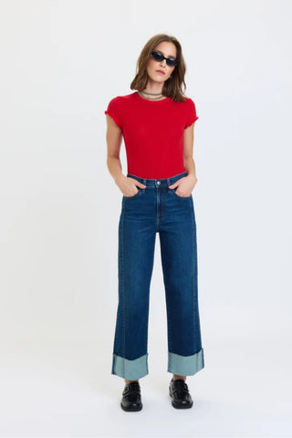 Model wearing high rise wide leg ankle jeans with contrast cuffed hem and black loafers