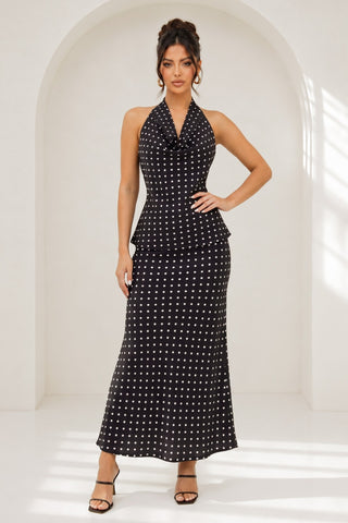 Woman wearing a black and white polka dot dress against a white background