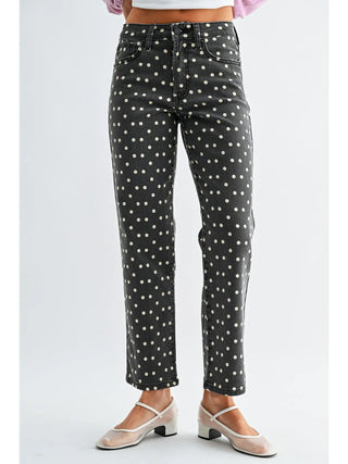 Black jeans with white polka dots worn by a person on a white background