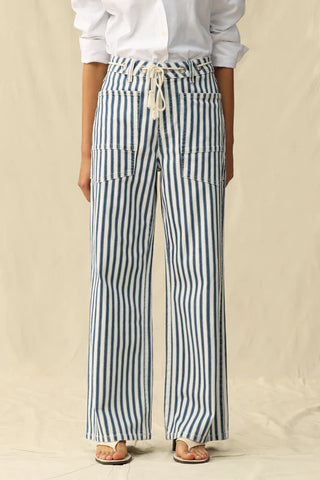 Person wearing blue and white striped pants on a beige background