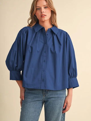 Cobalt blue button-front blouse with puff sleeves, pleated chest, and wide cuffs