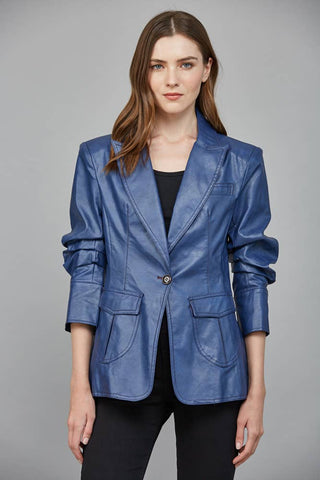 Woman wearing a blue leather jacket against a gray background