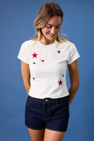 Woman wearing a white t-shirt with star patterns on a blue background