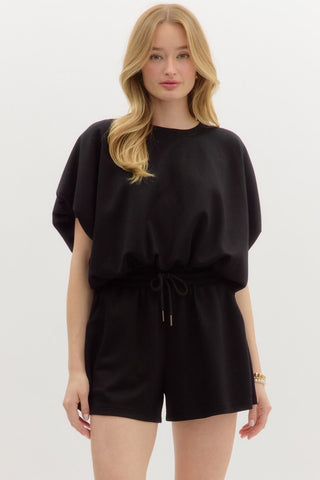 Woman wearing a black romper on a white background