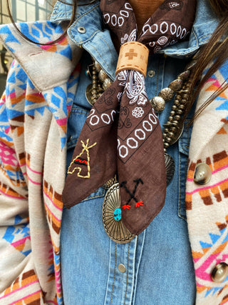 Close-up of a colorful jacket with embroidered bandanas and decorative buttons.