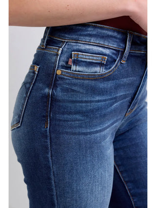 Close-up of blue jeans with a brand logo on a white background