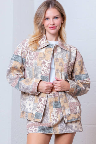 Woman wearing a patterned jacket against a plain background