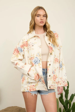 Woman wearing a floral jacket with a plain background