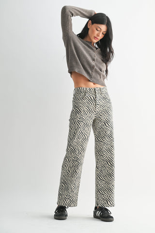 Model wearing wide-leg straight zebra print pants with cropped gray cardigan and sneakers