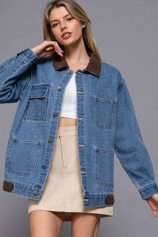 Woman wearing a blue denim jacket with brown collar and trim on a gray background