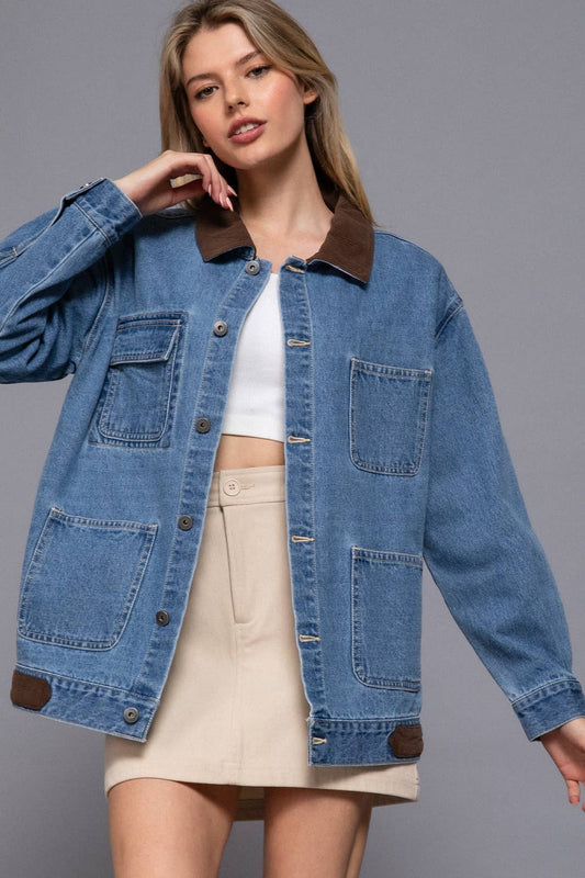 Woman wearing a blue denim jacket with brown collar and trim on a gray background