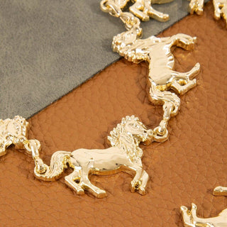 Gold-tone linked horse charm chain belt on tan leather background