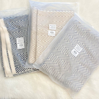 Chevron patterned scarves in navy, camel, and gray, packaged in clear bags