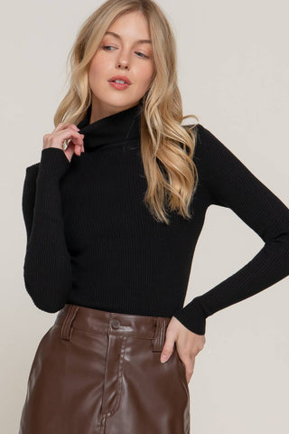 Black ribbed turtleneck long sleeve sweater styled with brown faux leather skirt