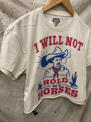 White cropped t-shirt with cowboy graphic and red blue I Will Not Hold My Horses text