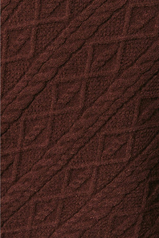 Close-up of brown cable knit fabric with textured diamond pattern