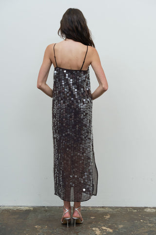 Back view of midi slip dress with large disc sequins and spaghetti straps, worn with heels