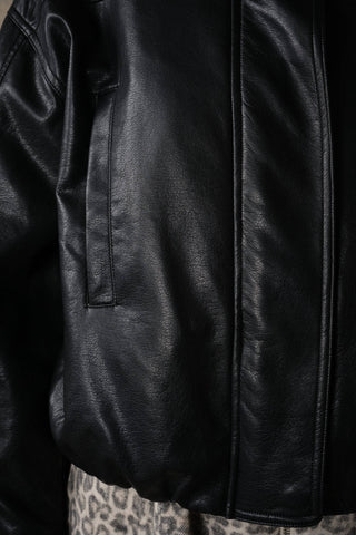 Close-up detail of faux leather jacket showing side pocket and seam construction