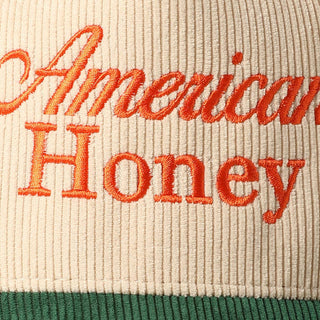Cream corduroy baseball cap with orange embroidered American Honey script and green brim