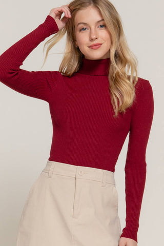 Crimson red ribbed turtleneck long sleeve fitted sweater on female model