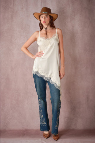 Ivory satin cami with lace trim and asymmetrical hem, styled with embroidered jeans
