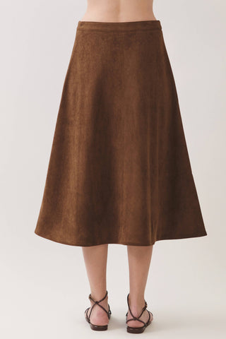 Back view of a midi-length A-line suede skirt with fitted waistband and strappy sandals