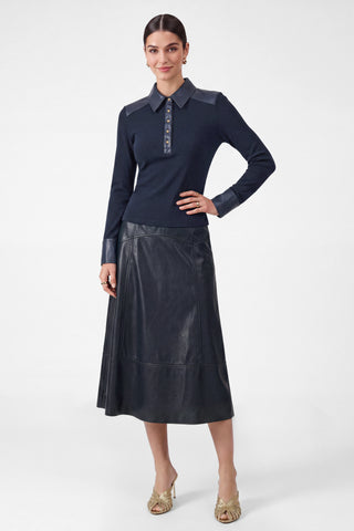 Model wearing a navy PU leather A-line midi skirt with visible panel seams and elasticized waist
