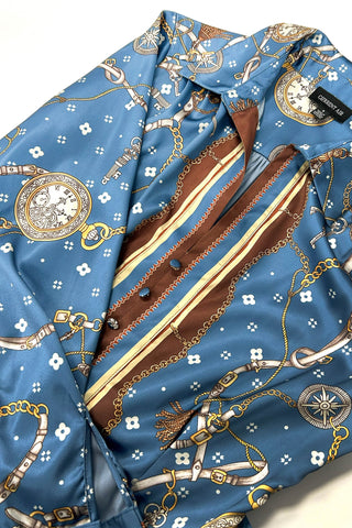 Flat lay detail of satin midi dress with chain, clock, and compass print pattern