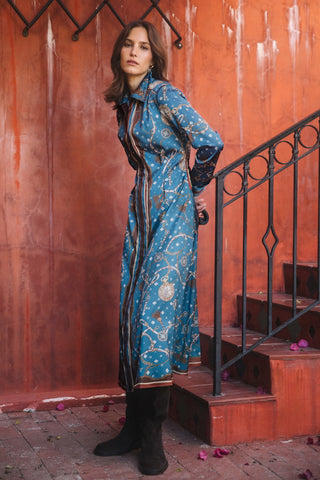 Model wearing a long-sleeve printed midi dress with collar and button-down front, styled with knee-high boots