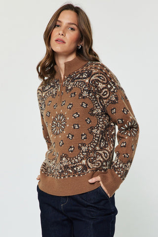 Woman wearing a paisley jacquard half-zip long sleeve pullover sweater with dark jeans