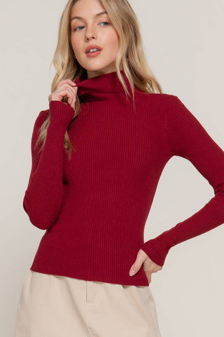 Fitted ribbed burgundy turtleneck sweater with long sleeves on female model