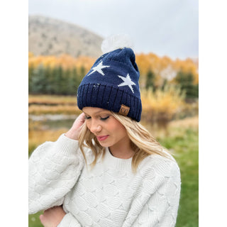 Navy blue knit beanie with white stars and white pom pom, CC brand
