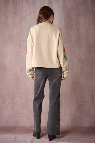Cream oversized sweatshirt with red floral and green paisley sleeve print, back view